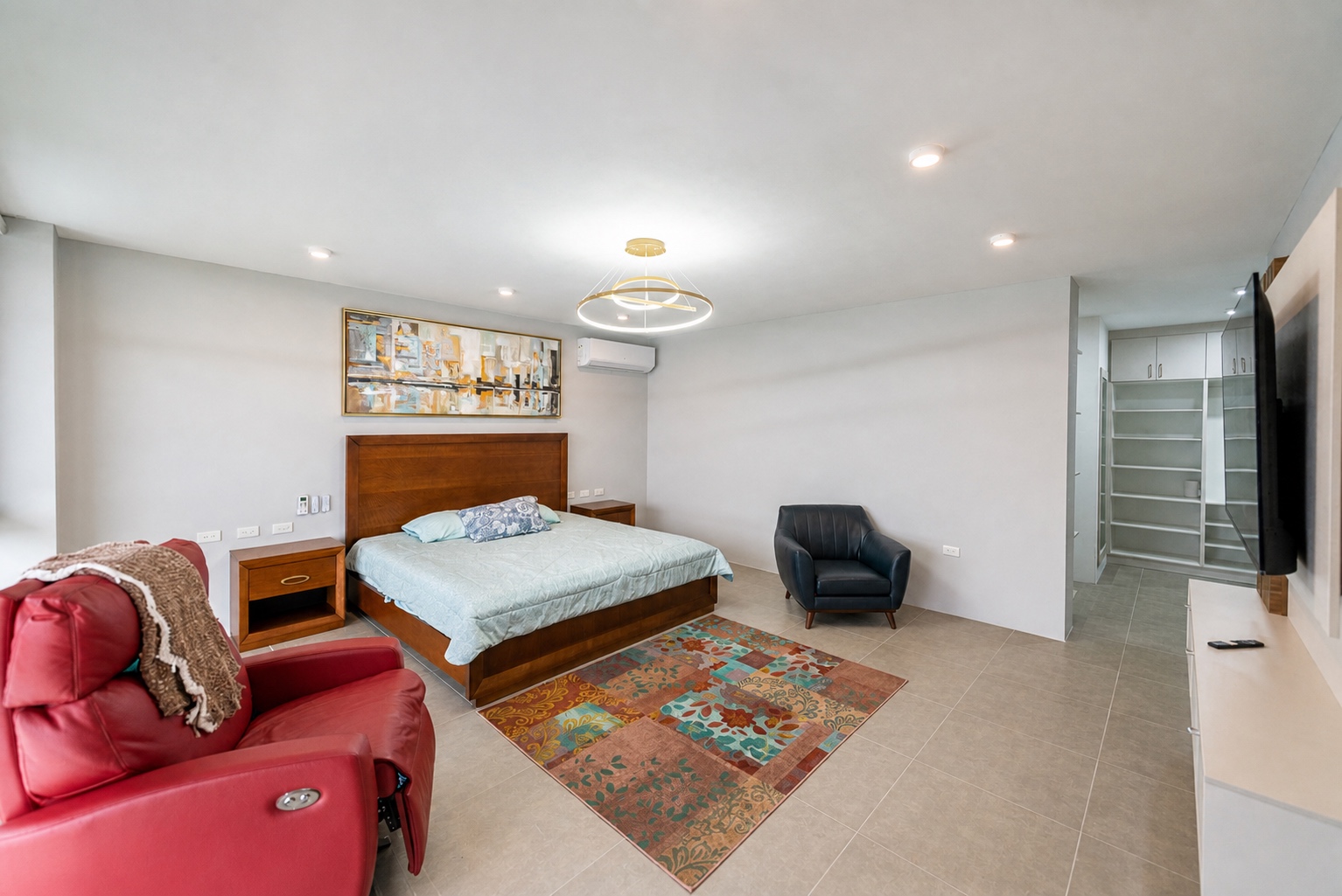 Spacious primary suite with seating, television, and ocean views