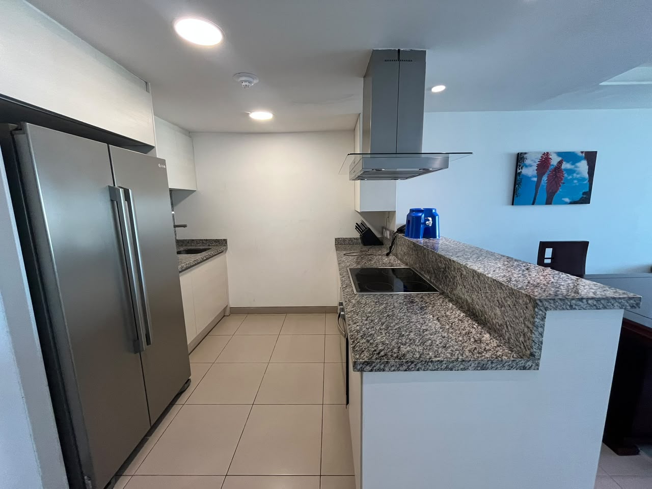 Modern fully equipped kitchen with granite counters and stainless steel refrigerator