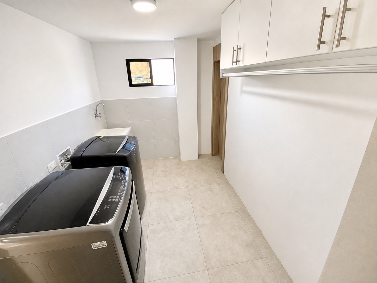 Private laundry room with washer, dryer, utility sink, and storage