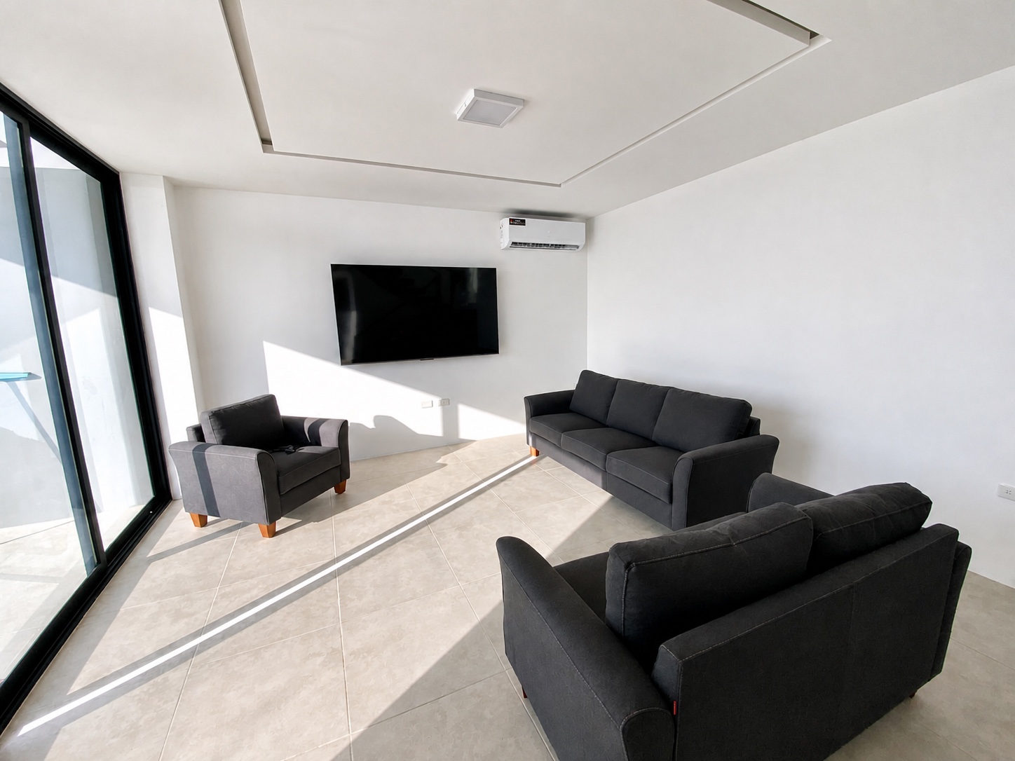 Sunlit upstairs lounge with television and comfortable seating
