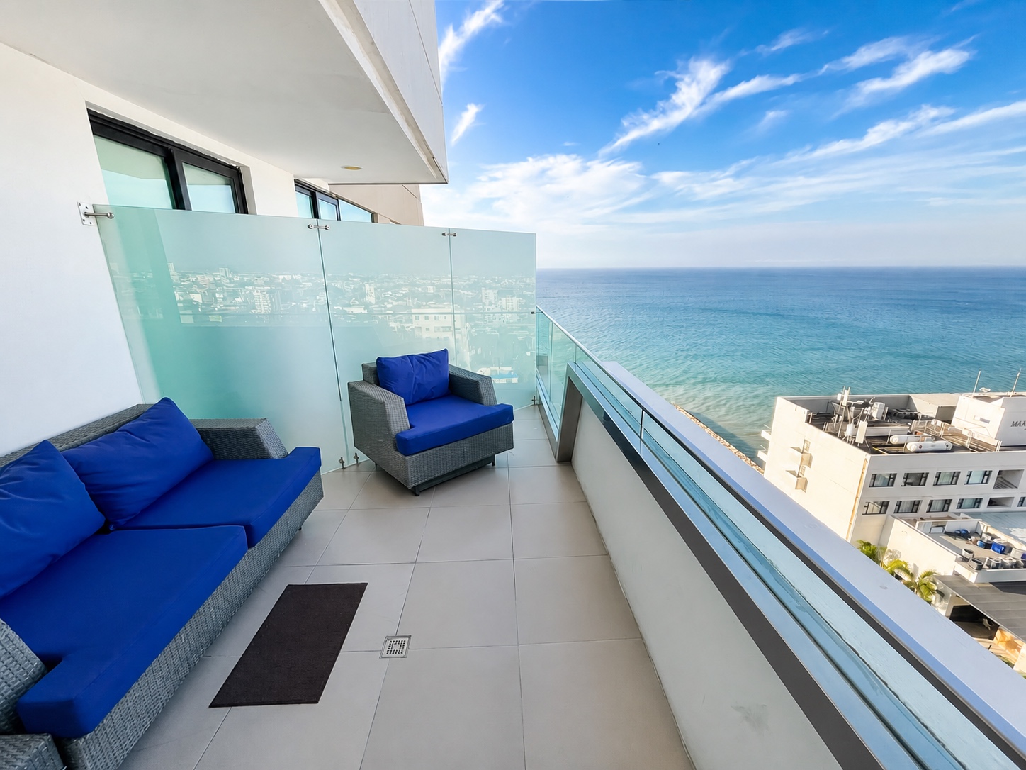 Private balcony lounge with blue outdoor furniture overlooking the Pacific Ocean