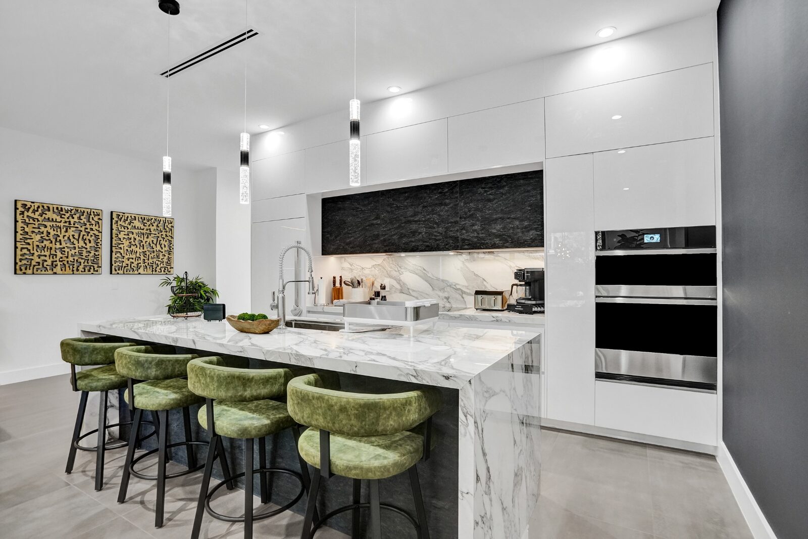 Bright contemporary kitchen with marble island, pendant lighting, and bar seating