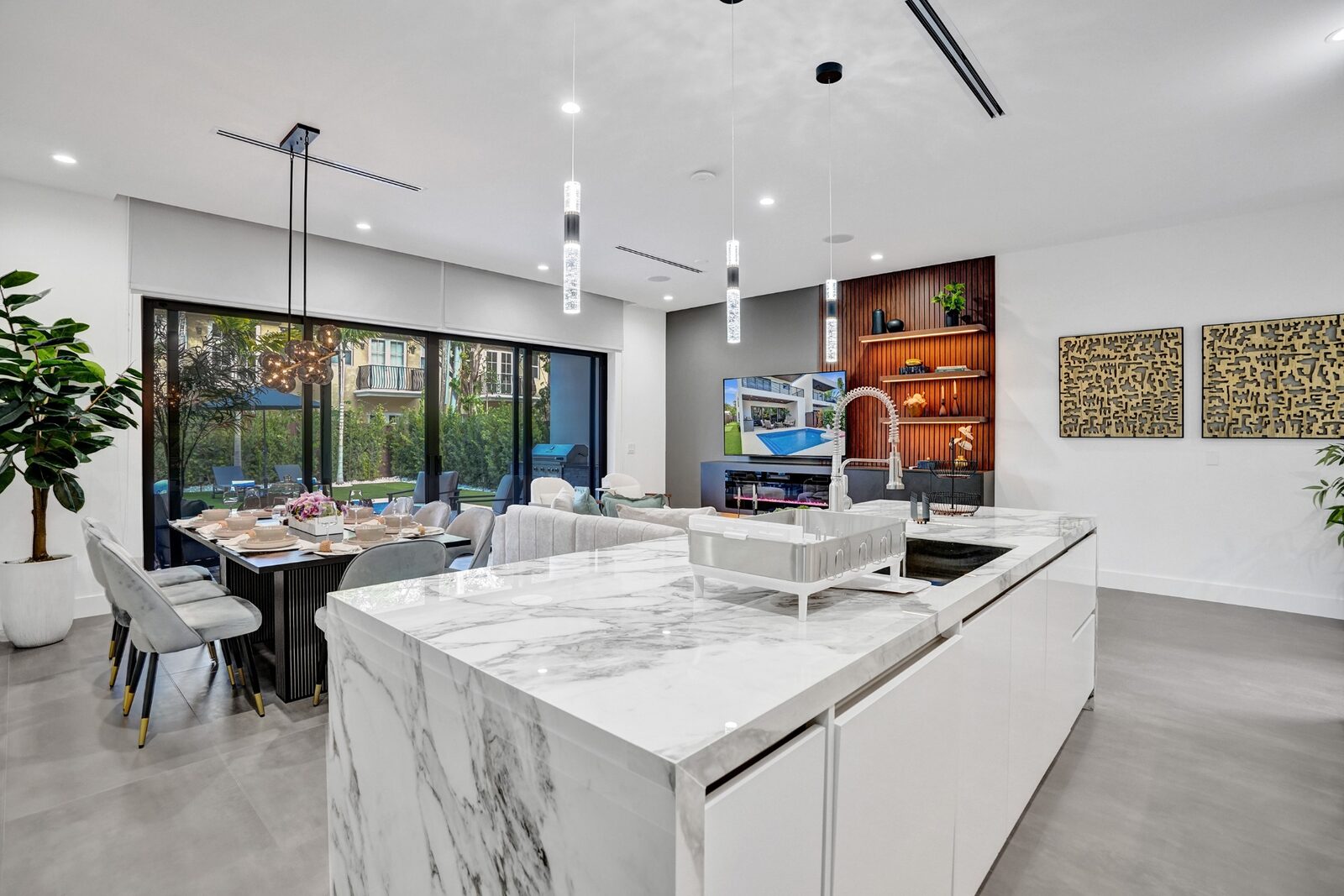Wide kitchen and dining overview with marble island and modern decor